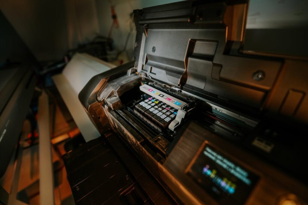 Close-up view of an inkjet printer with exposed cartridges in a workspace setting.